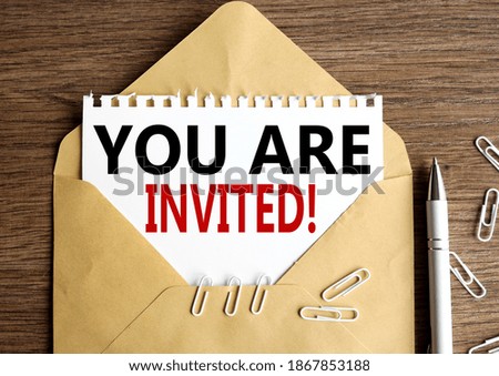 you are invited !. text on white paper in craft envelope on wood table