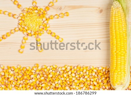 Abstract picture from grains of crude corn on a wooden surface