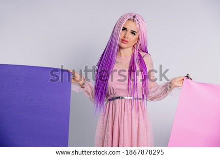 Sad girl with pink hair in dress with two yoga mats. No sport, white background.