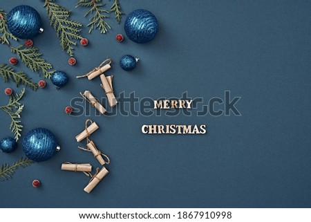 New Year's decor, little notes and the inscription Merry Christmas on a blue background. Copy space, flat lay, mock up, top view.