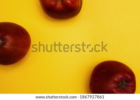 Large red apples on a bright yellow background. Fruits that are useful for vitamins. Vegetarianism and proper nutrition. Space for text, banner
