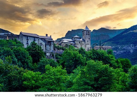 Rural landscape traditional architecture in the Pyrenees, mountain village at sunrise with high mountains and green trees. Torla Ordesa.
