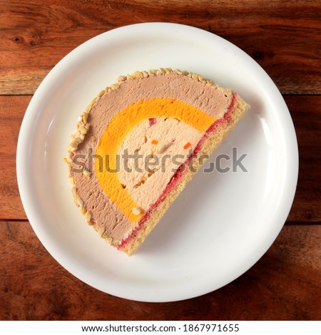 Colorful Cassata ice cream is served in a white plate over a rustic wooden table, Thumbnail picture