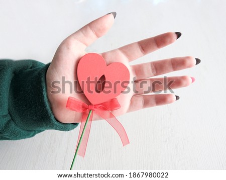 Heart in a woman's hand. Light background. Concept for Valentine's Day, Mother's Day. Greeting card, banner