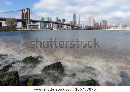 Manhattan skyline and Brooklyn Bridge with waves ot the Hudson river