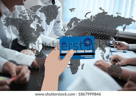 hand holds a credit card against the background of the world map and people sitting at the table. Contactless payment concept