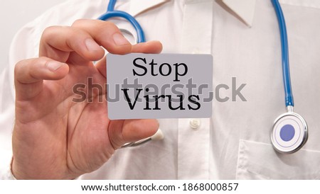 stop virus text on a business card in the doctor's hand.