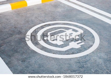 EV or electric car charging sign painted on the ground of parking lot in gas station in Thailand