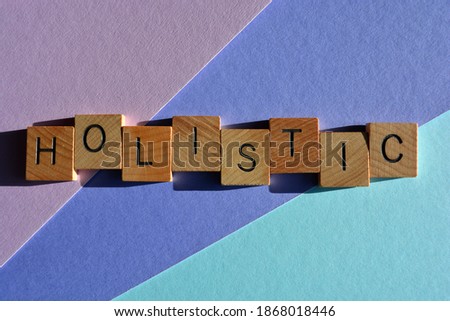 Holistic, word in wooden alphabet letters isolated on pastel coloured background with copy space