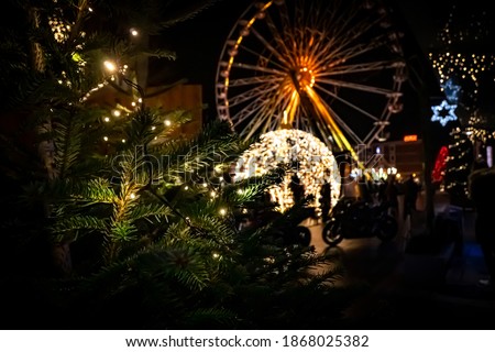 A city in Christmas time. The picture was taken in the evening to bring out the beautiful lights. The image is deliberately blurred, the left foreground is sharp. Nice bucket. 