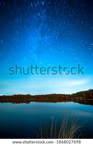View of the milky way at night reflected in a pont