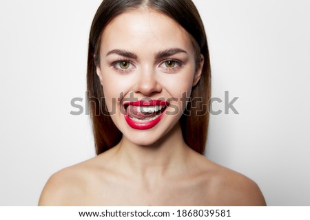 Woman with bared shoulders red lips showing tongue grimace studio 