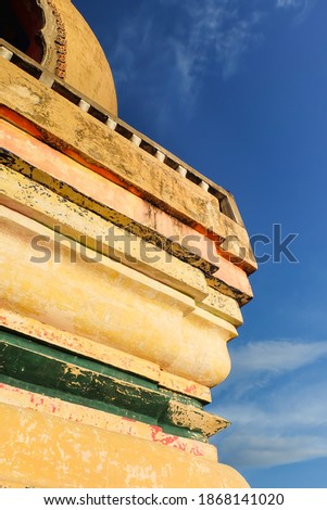 Thai Buddhist stupa in temple against blue sky background, Thailand.