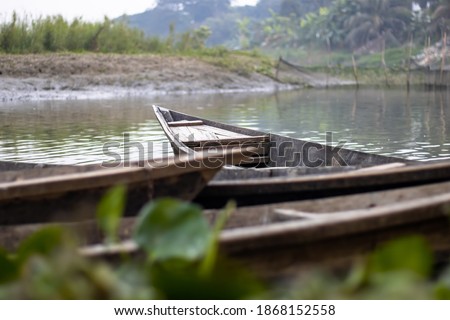 Wooden boats parked at the bank of a small river
