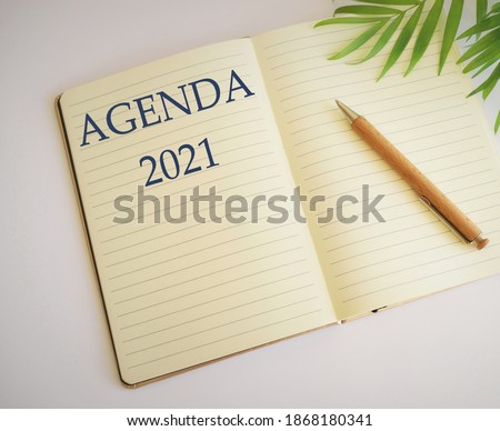 Conceptual hand writing showing Agenda. Business photo showcasing list items that participants hope to accomplish at meetings. Agenda 2021 text written in notebook.