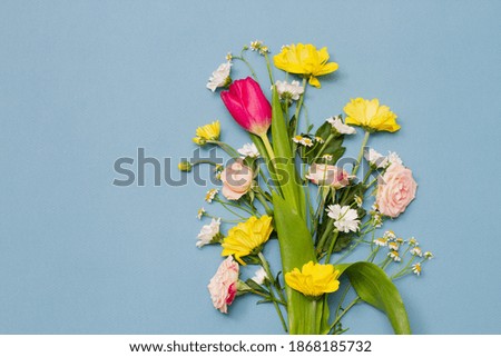 large varied spring bouquet on pastel blue background with copy space. Close-up . Floral minimalism. Spring holidays concept