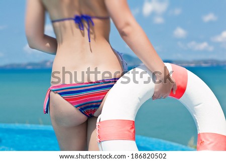 bottom of Young woman with floating equipment enjoying the ocean view