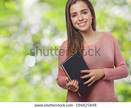 pretty young woman smiling and holding a book