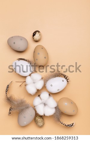Easter eggs on beige pastel background with space for text. Flat lay image composition, top view. Easter decoration, minimalist egg design, modern design template.