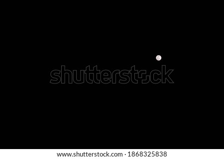 View of the bright full moon in night sky. Empty space for text.