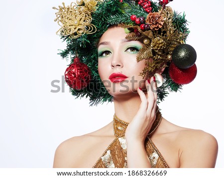 Christmas Winter Woman, fashion model. Beautiful New Year and Christmas tree festive hairstyle and makeup. Celebration.