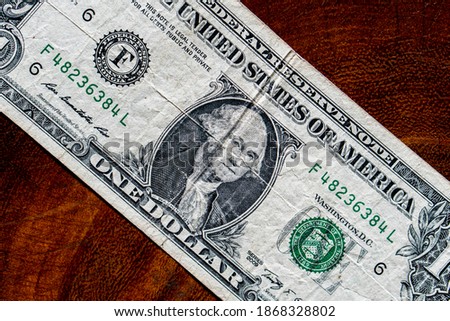 close up details of 1 dollar bill on wooden board