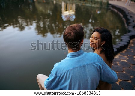 Love couple embracing at the pond in summer park