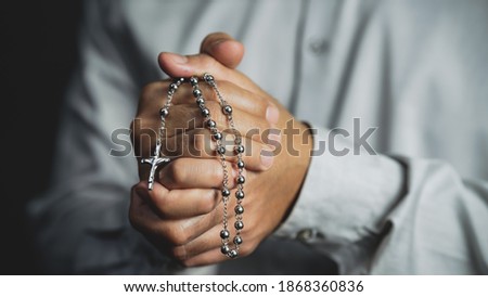 christianity background of man hand holding cross rosary praying for god blessing. Concept of christianity people fait and practice Royalty-Free Stock Photo #1868360836