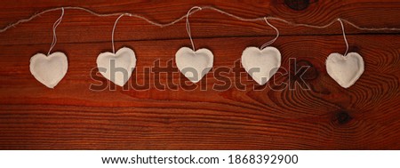 Valentines Day concept header design, website banner flat lay.Eco linen hearts garland on wooden background. Decorative white heart on jute string. Hand made decorations flatlay. Advertising template.