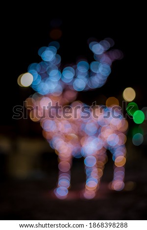 Christmas light bokeh illumination vertical picture with abstract deer silhouette street decoration festive object 