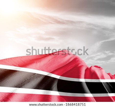 Trinidad and Tobago national flag cloth fabric waving on beautiful sky background.