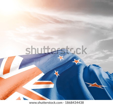 New Zealand national flag cloth fabric waving on beautiful sky background.