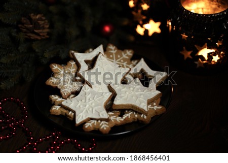 ginger cookies in icing sugar on a plate on a dark background