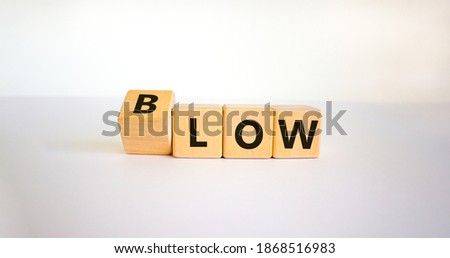 Low blow symbol. Turned a cube and changed the word 'low' to 'blow'. Beautiful white background, copy space. Business and low blow concept.