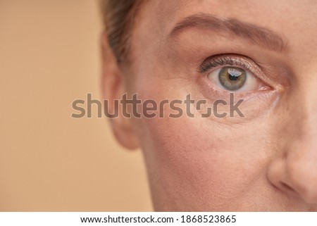 Mature woman with wrinkled eyes in studio Royalty-Free Stock Photo #1868523865