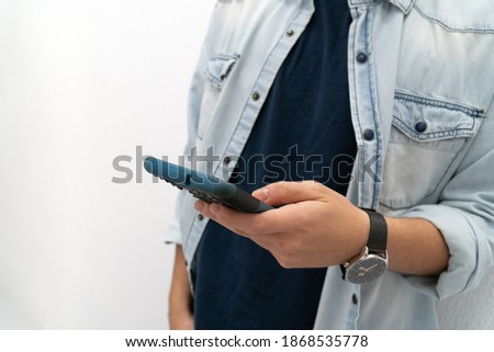 Close-up of a teenager's hands using a smart phone on a white background