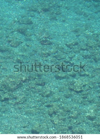 Turquoise sea with clear view and stones and rocks at the ground