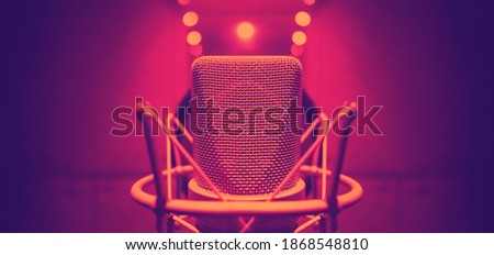 Studio microphone with shock mount and pop filter on tripod stand for sound engineer and singer or announcement on air studioroom. microphone and equipment concept.