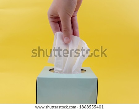 Women hand picking white napkin. white tissue paper from the blue tissue box Royalty-Free Stock Photo #1868555401