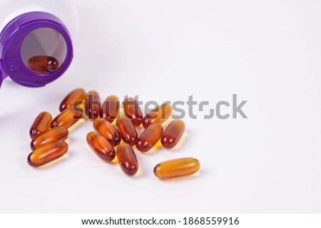 Omega 3 fish oil or lecithin capsules.Pile of brown softgel pills closeup on white background.Healthy nutrition and lifestyle concept. Nutraceuticals with omega3 polyunsaturated fatty acids. Royalty-Free Stock Photo #1868559916