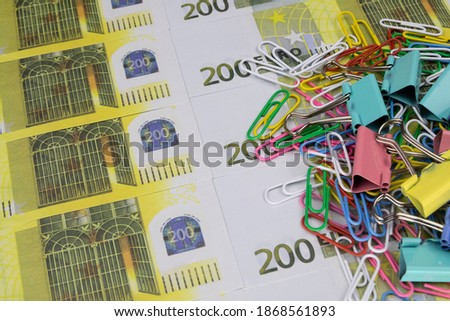 There is a stack of colored paper clips and clips on the 200 euro banknotes
