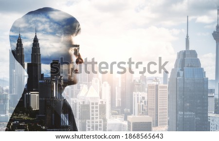 Front view of young businessman on city background. Success and research concept. Double exposure