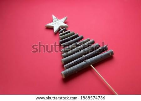 do it yourself: eco Christmas tree made of twigs and wooden star. Step 3: on a red background, there is a finished Christmas tree on a wooden bamboo skewer