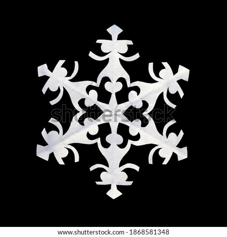 A handmade white paper snowflake isolated on black