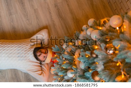 Christmas wallpaper poster picture of relaxation man on floor of his own flat with decorated tree by toy and garland lights peaceful atmosphere 