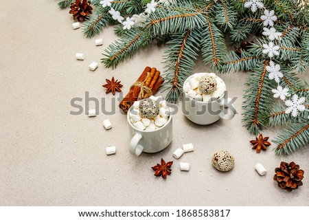 Christmas poster template composition with mugs of hot chocolate, cinnamon sticks, marshmallows and fresh fir tree branches. New Year good mood, stone concrete background, copy space