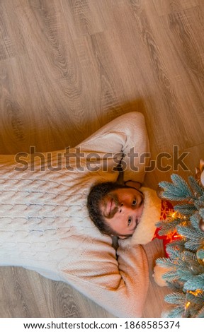 lonely man lay on floor of his home near Christmas tree winter holidays season time vertical picture wallpaper background concept picture 