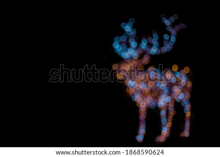 abstract bokeh circles of deer animal shape from garland lamps Christmas lights isolated on black empty copy space for your text here  