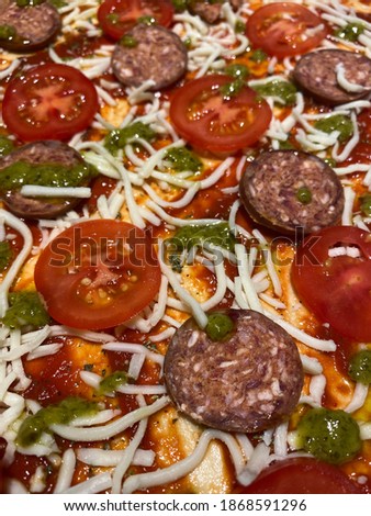 Homemade pizza with sausage and pesto