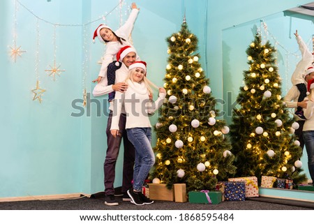 happy young family with one child holding christmas gift and smiling at camera